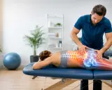 Fizjoterapeuta wykonuje terapię manualną kręgosłupa. Częstotliwość zabiegów zależy od stanu pacjenta.