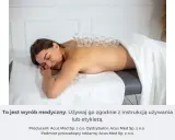 Kobieta leży na plecach, na jej kręgosłupie umieszczono szklane bańki na plecy.