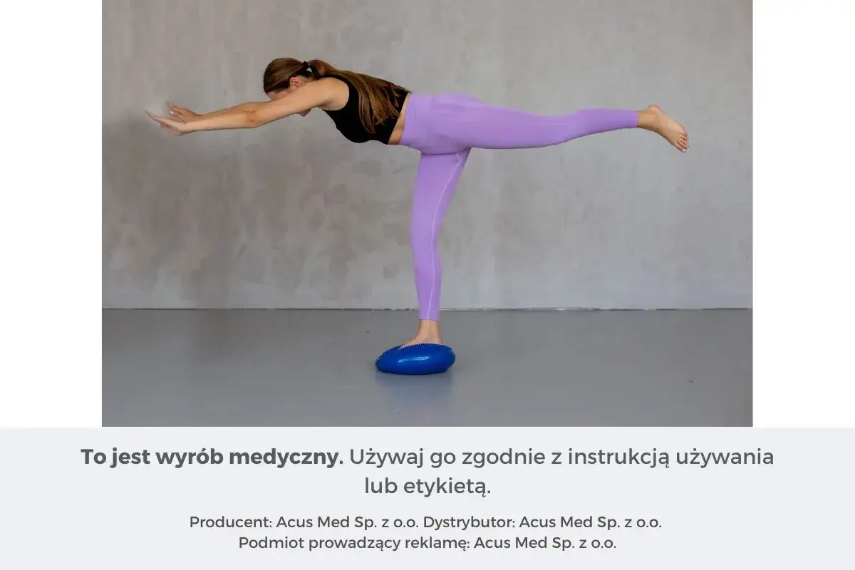 Kobieta wykonuje ćwiczenia sensomotoryczne na niebieskiej poduszce balansującej, unosząc jedną nogę.